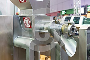 Close up outlet tube or discharge gate of automatic commercial meat grinder or masher machine for food industrial