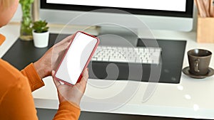 Businesswoman using mobile phone at office desk.