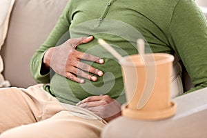 Close up of overeaten man and cup of takeaway food