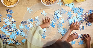 Close Up Overhead Shot Of Children Indoors At Home Doing Jigsaw Puzzle Together photo