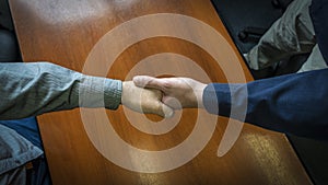 Close-up overhead shot of two men shaking hands