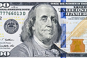 Close up overhead view of Benjamin Franklin face on 100 US dollar bill. US one hundred dollar bill closeup. Heap of one hundred