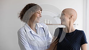 Close up overjoyed doctor and hairless woman laughing, celebrating success