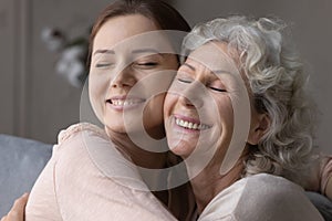 Happy elderly mother and senior daughter hug and cuddle photo