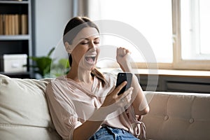 Close up overjoyed woman holding phone, screaming with joy