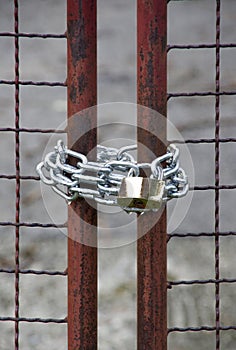 Close up of a padlock, gate and chain