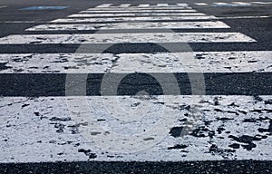 close up of painted lines on asphalt on a pedestrian crossing zebra crosswalk