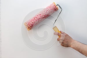 Close up of painter arm painting a wall with paint roller