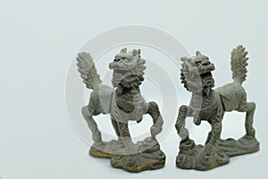 Close-up of a pair of Chinese bronze Qilin figurines, with a dragon head, deer antlers, fish scales, ox hooves & lion tail