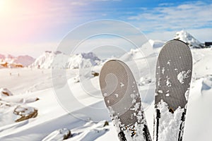 Close-up pair of skis on mountain winter resort with ski-lift and beautiful winter mountain panoramic scenic view