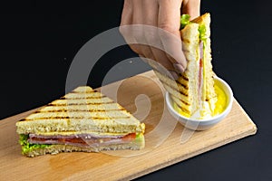 Close up on pair of young girl`s hands removing a healthy wholesome wholemeal bread ham sandwich