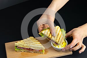 Close up on pair of young girl`s hands removing a healthy wholesome wholemeal bread ham sandwich