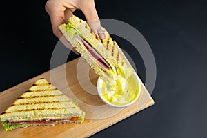 Close up on pair of young girl`s hands removing a healthy wholesome wholemeal bread ham sandwich