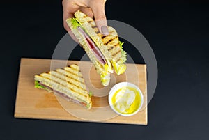 Close up on pair of young girl`s hands removing a healthy wholesome wholemeal bread ham sandwich