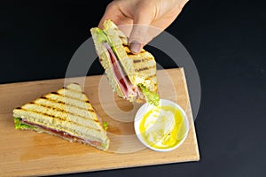 Close up on pair of young girl`s hands removing a healthy wholesome wholemeal bread ham sandwich