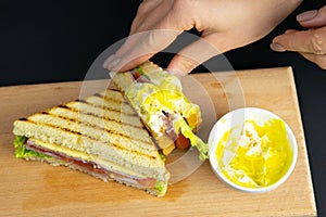 Close up on pair of young girl`s hands removing a healthy wholesome wholemeal bread ham sandwich