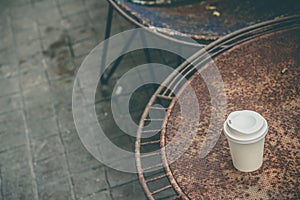 Close up paper cup on the rusty table