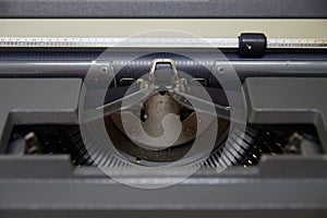 Close-up of the paper press, the roller, the ribbon of a manual typewriter