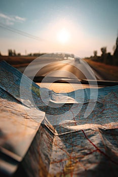 Road trip map on car dashboard at sunset