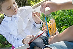 Close-up, in the park, in the fresh air, from a large number of pencils, the students choose a sharpened