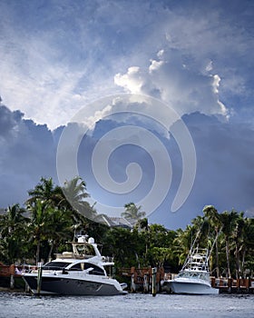 Close up parked boats at dock on canal over storm sky in Florida