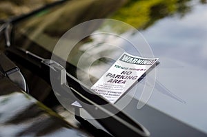 Close-up of parking ticket on car`s windshield