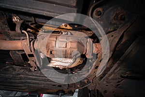 Close-up on the part of the bottom of the car from the front of the exhaust pipe and the catalyst disassembled during the repair photo