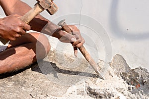 Close up Part of a construction labor working with hammer and Chisel in a construction site