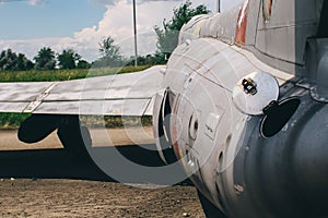 Close-up of part of the fuselage of an old military fighter jet, which has an open fuel system. The open tank of the aircraft, the