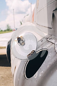 Close-up of part of the fuselage of an old military fighter jet, which has an open fuel system. The open tank of the aircraft, the