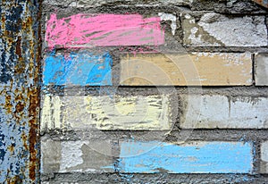 Close up of part of a gray brick wall with with colour chalk on it