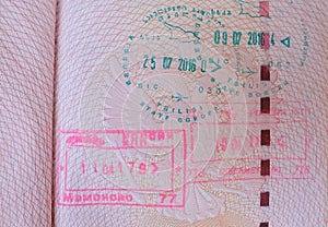 close up part of pages of foreign passport with foreign visas, border stamps, permits to enter countries, concept of traveling