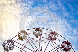 Close up part of pastel Ferris wheel on blue sky