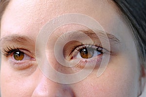 Close up part of the woman`s face, girl 20-29 years old, human eye looking to the side, the concept of surveillance, peeping,