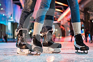 close-up partial view of young couple in skates ice skating