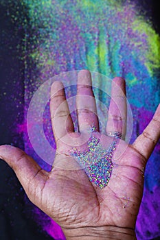 close-up partial view of young people holding colorful powder in hands at holi festival