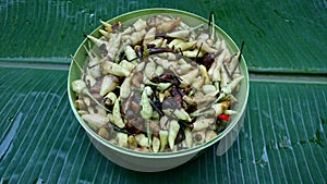 Close-up of partially rotten green chilies in a green container