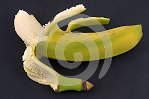 Half-peeled banana close-up on black background