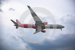 Close-up of a passenger plane flying against on the background of a stormy sky and clouds