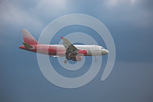 Close-up of a passenger plane flying against on the background of a stormy sky and clouds