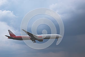 Close-up of a passenger plane flying against on the background of a stormy sky and clouds