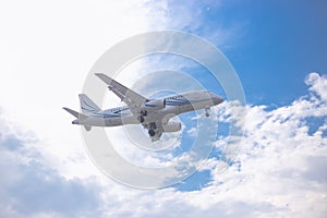 Close-up of a passenger plane flying against a blue sky