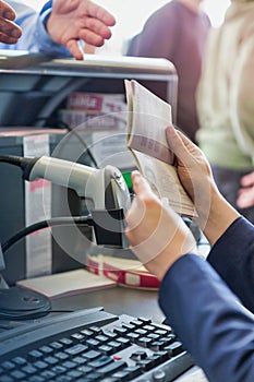 Close up of passenger service agent looking at mature man passport in airport