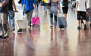 Travelers with suitcases walking through the airport photo