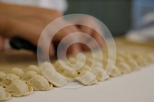 Close up of pasta making process. Woman makes orecchiette, ear shaped pasta, traditional to the Puglia region of Italy.