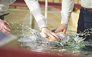 Close up of pastors hands who baptize man photo