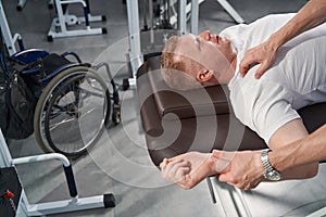 Close up patient doing hand stretching exercise on massage table