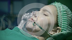 Close-up, a patient in an operating room who is using an oxygen mask to help them breathe.