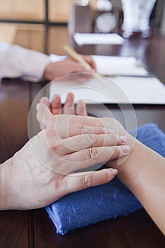 Close Up of Patient's Hand While Doctor Takes Pulse