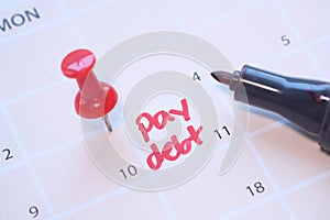 Close up of pay debt word on calendar.